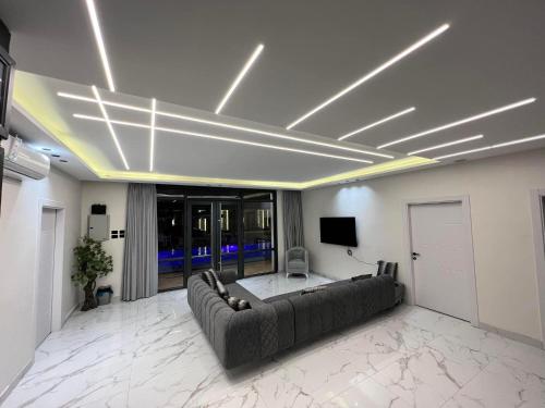 a living room with a couch and a tv on the ceiling at Tixos Farm in Irbid
