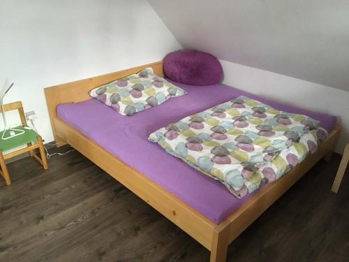a bed with a purple mattress and two pillows at U Rozlitýho mlíka in Chvaleč