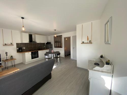 Il comprend un grand salon avec un canapé et une cuisine. dans l'établissement Résidence de la Poste, à Saint-Pol-de-Léon