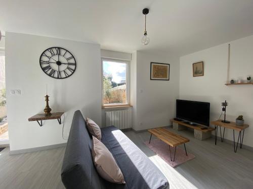 un salon avec un canapé et une horloge au mur dans l'établissement Résidence de la Poste, à Saint-Pol-de-Léon