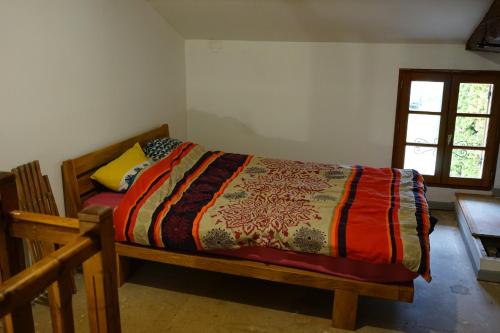 a bedroom with a bed with a colorful comforter at Gîte charentais in Gémozac