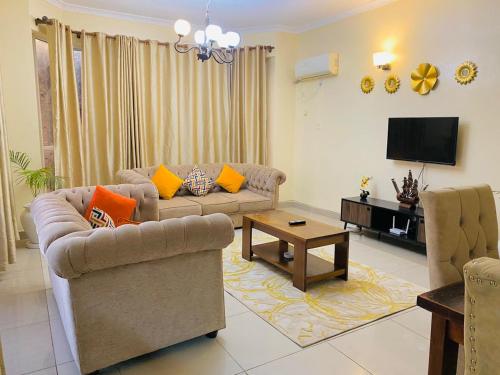 uma sala de estar com dois sofás e uma televisão em Danmic em Mombasa