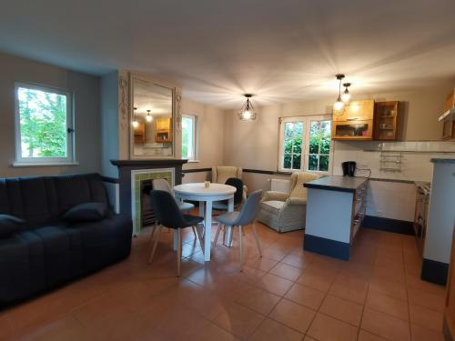 eine Küche und ein Wohnzimmer mit einem Tisch und Stühlen in der Unterkunft Gîte vallée du denacre entre terre et mer in Wimille