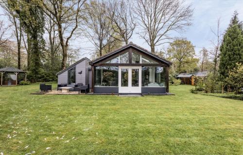 a small house with a conservatory in a yard at Vakantiewoning De Vlinder, Bakkeveen in Bakkeveen