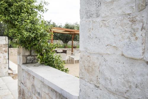 a stone wall with a patio in the background at Masseria Gravelle in Turi