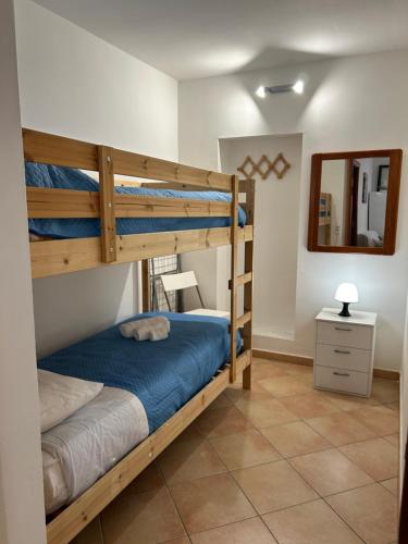 een slaapkamer met 2 stapelbedden en een spiegel bij A casa ru zu Nino in Capaci
