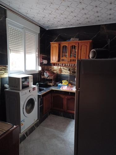 een keuken met een koelkast en een wasmachine bij MAISON DE VACANCE in Mostaganem