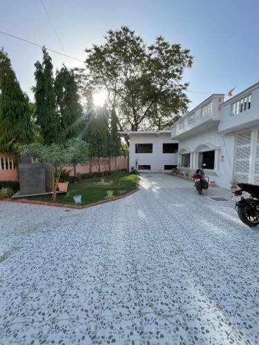 a driveway of a house with a motorcycle parked in the driveway at Best Home Stay in Nagla Dhīmar