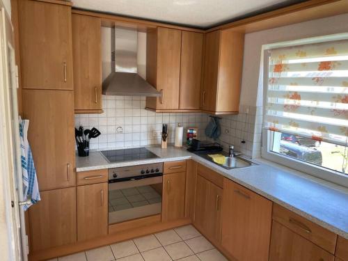 a kitchen with wooden cabinets and a stove top oven at Sofi Wohnung in Reutlingen