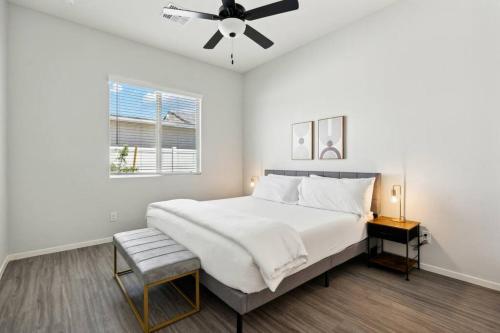 a white bedroom with a bed and a ceiling fan at Gleaming Contemporary Home in Buckeye with Pool,BBQ in Buckeye