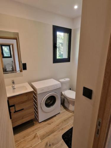 une salle de bain avec machine à laver et toilettes dans l'établissement Belle villa à la campagne dans un coin cosy, à Sartène