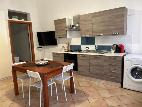 a kitchen with a table and chairs and a washing machine at A casa ru zu Nino in Capaci
