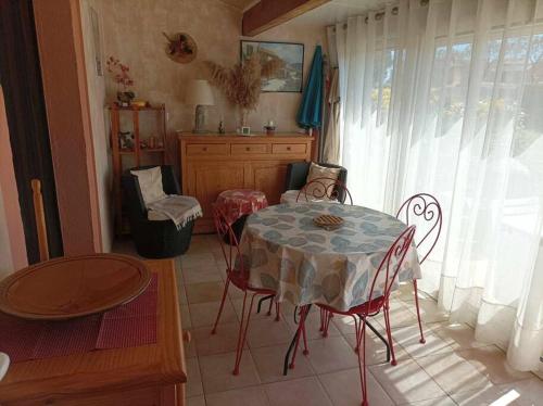 une salle à manger avec une table et des chaises et une fenêtre dans l'établissement Appartement T3 en duplex, à Vias