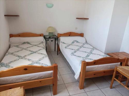 une chambre avec deux lits et une table avec une lampe dans l'établissement Appartement T3 en duplex, à Vias