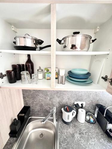 a kitchen shelf with pots and pans and a sink at Franziskaner Suites #6 in Graz