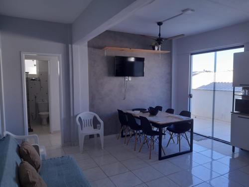 a kitchen and dining room with a table and chairs at Suites e Kitnets praia Iriri in Anchieta