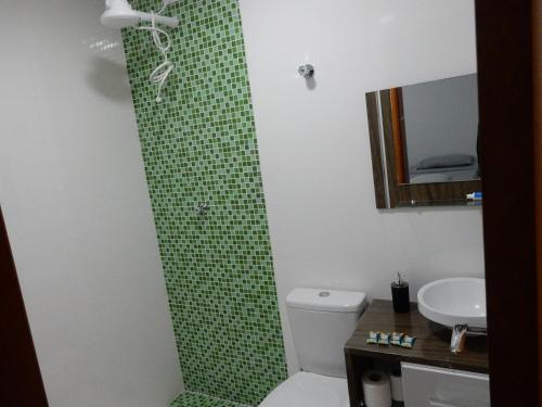 e bagno con doccia, servizi igienici e lavandino. di Casa sobrado 7 a Guarujá