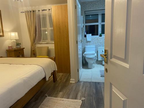 a bedroom with a bed and a bathroom with a toilet at ROOM ONLY- option of the entire house if available - private property in quiet estate in Nottingham