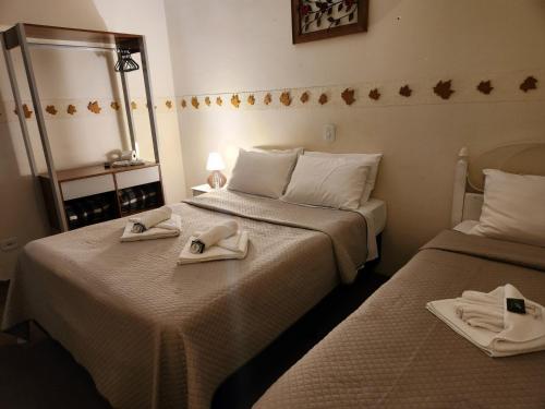duas camas num quarto com toalhas em Pousada Araucária em Campos do Jordão