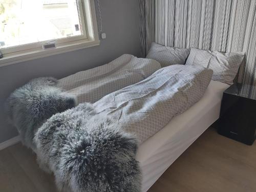 a bed with a blanket and pillows on it at Nearby Bergen, Midtunlia 27d in Bergen