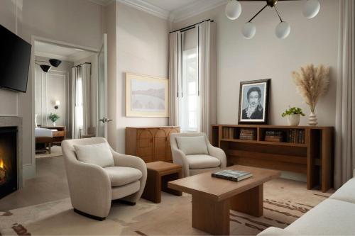 a living room with two chairs and a fireplace at Plaza San Antonio Hotel & Spa, Autograph Collection in San Antonio