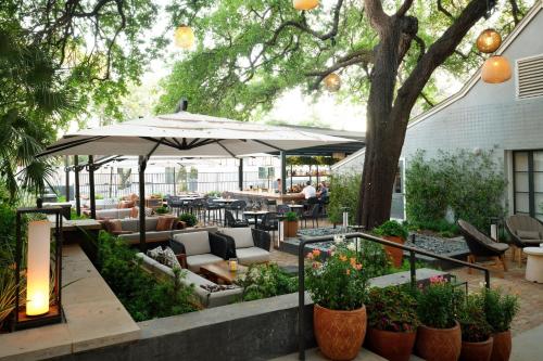 a patio with tables and chairs and an umbrella at Plaza San Antonio Hotel & Spa, Autograph Collection in San Antonio