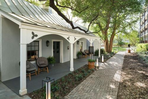 a white house with a patio with chairs and trees at Plaza San Antonio Hotel & Spa, Autograph Collection in San Antonio