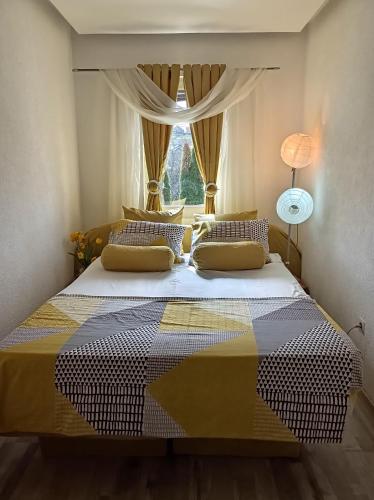 a bedroom with a large bed with a window at Kavkaz Apartment in Sarajevo