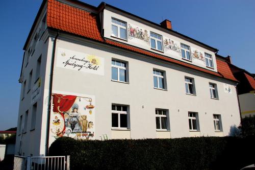 un edificio blanco con un mural en el costado en Spielzeughotel Sonneberg, en Sonneberg