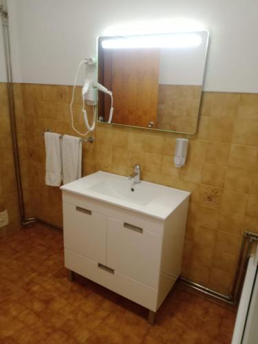 a bathroom with a white sink and a mirror at Residencial Morgado in Almeida