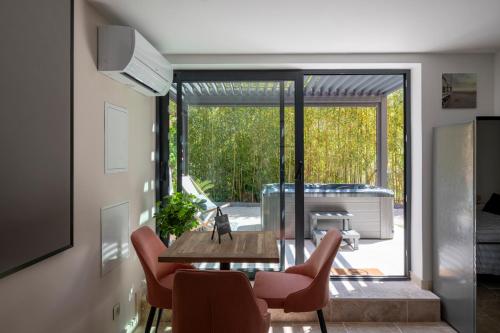 d'un salon avec une table et des chaises ainsi que d'une terrasse. dans l'établissement Honey Moon - studio romantique Jacuzzi et écran cinema, à La Ciotat