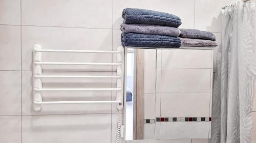 a stack of towels on a shelf in a bathroom at Butas ant ežero kranto in Telšiai