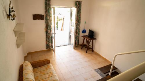 uma sala de estar com um sofá e uma porta de vidro deslizante em Residence Palummera em Ischia