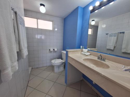 a bathroom with a sink and a toilet at Playa Inn Rocky Point in Puerto Peñasco