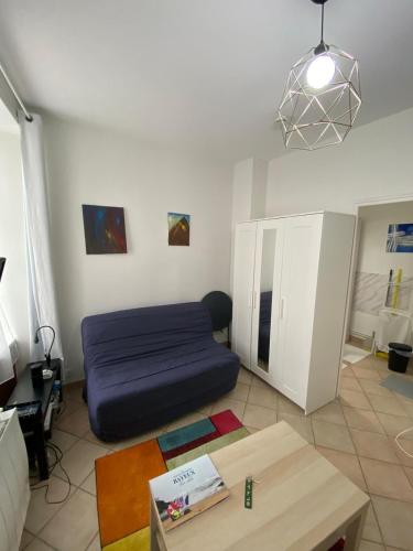 un salon avec un canapé bleu et une table dans l'établissement BAYEUX DDAY 80e STUDIO à côté de la Cathédrale, à Bayeux