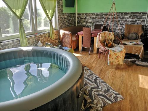 a bath tub in a living room with a swing at Sunny Side Fruska Gora -touristic estate in Velika Remeta