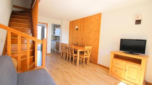 un salon avec une télévision et une table avec des chaises dans l'établissement Résidence Parc Aux Etoiles - CH13PAE - CHALET DUPLEX 2 CHAMBRES, BORD DE PISTE MAE-2264, à Narreyroux