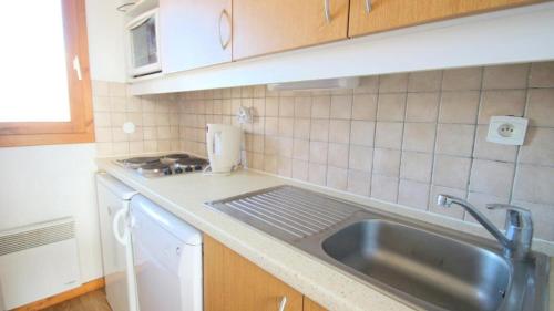 una cocina con fregadero y encimera en Résidence Parc Aux Etoiles - CH13PAE - CHALET DUPLEX 2 CHAMBRES, BORD DE PISTE MAE-2264, en Narreyroux