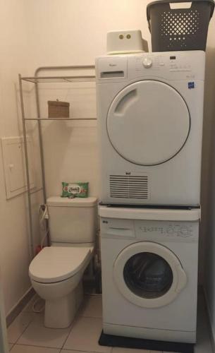 une petite salle de bains avec un lave-linge et des toilettes. dans l'établissement Idéal JO - Appartement - Résidence Les Parisiennes, à Aubervilliers