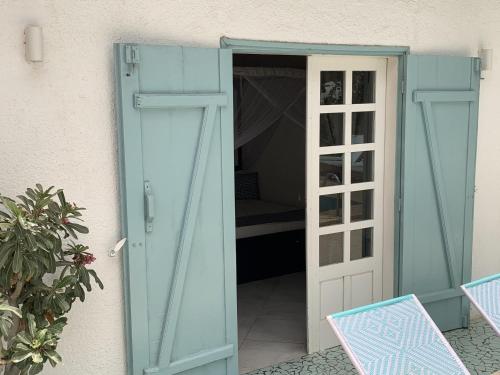 a door leading into a room with a bed behind it at West AFRICAN BEACH in Sali Nianiaral