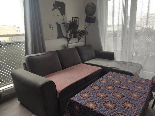 un salon avec un canapé et une table dans l'établissement Idéal JO - Appartement - Résidence Les Parisiennes, à Aubervilliers
