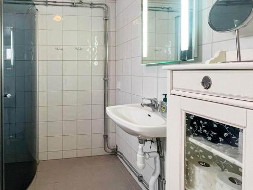 uma casa de banho branca com um lavatório e um chuveiro em Holiday home STENSJÖN em Boda