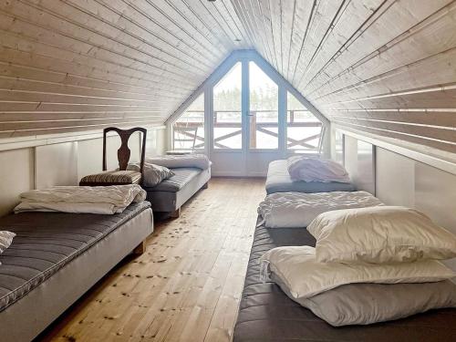 um quarto com 3 camas e uma grande janela em Holiday home STENSJÖN em Boda