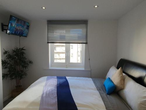 um quarto com uma cama grande e uma janela em Cosy Sea front LUXURY Studio Apartment Flat Brighton & Hove em Brighton & Hove