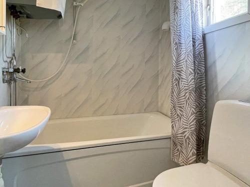 a bathroom with a shower curtain next to a sink at Holiday home OSKARSHAMN II in Oskarshamn