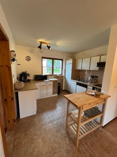 a kitchen with white cabinets and a wooden table at U farmy in Velhartice