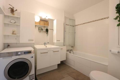 y baño con lavadora y lavamanos. en Appartement calme et lumineux proche Paris, en Asnières-sur-Seine