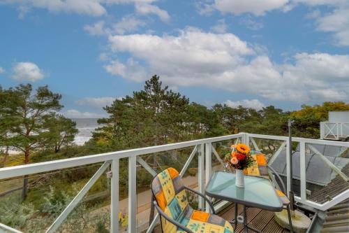 d'un balcon avec une table et des chaises donnant sur l'océan. dans l'établissement Meerblick Heringsdorf, à Heringsdorf