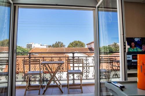 a balcony with two chairs and a table on a balcony at Downtown Lavrio Port Cozy Apt in Lávrion