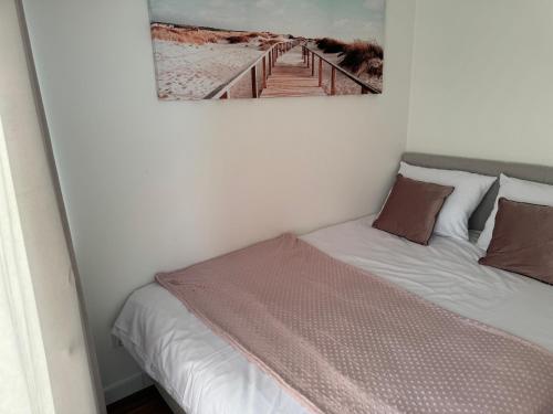 a bedroom with a bed with a picture on the wall at Baltic Marina 30m in Kołobrzeg
